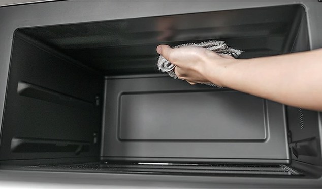 バルミューダオーブンレンジの庫内を布で拭いている様子。フラットな構造で段差がなく、汚れが落としやすいデザイン。