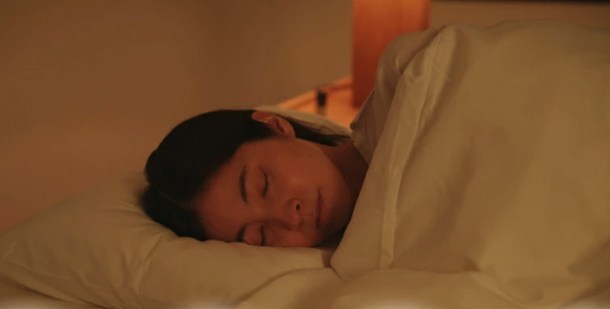 あたたまった布団の中で気持ち良さそうに眠っている女性の写真。リラックスした様子から入眠の快適さが伝わる。