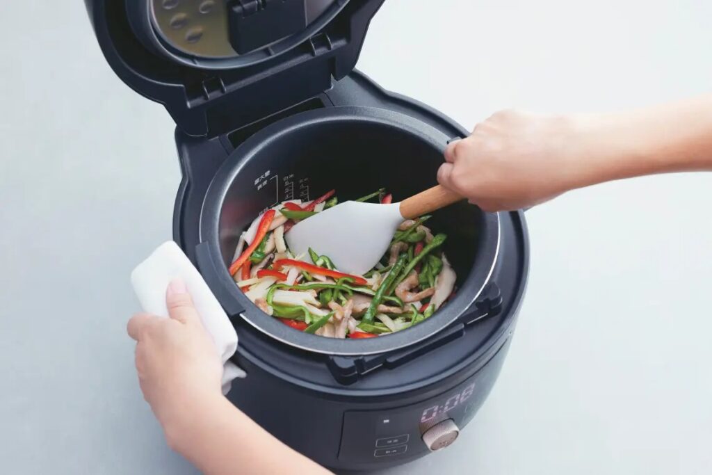 タイガー電気圧力鍋を使って具材を炒めている様子。深めの内鍋で食材をこぼさず調理可能