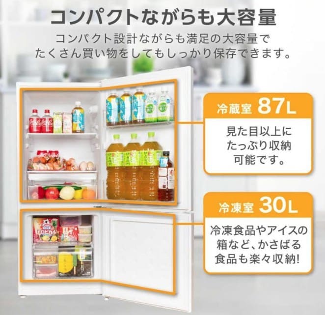 マクスゼンの2ドア冷蔵庫（117Lモデル）の庫内写真。冷蔵室87Lと冷凍室30Lの容量が示され、2Lペットボトルや野菜、冷凍食品がたっぷりと収納されている様子が紹介されています。