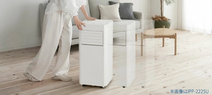 アイリスオーヤマのポータブルクーラーをキャスターで女性がリビングに移動させている様子