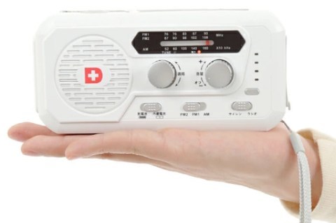 ソーラー多機能ラジオライト5000を片手に乗せてコンパクトなサイズ感を示している画像